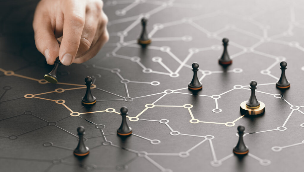 Hand moving a game piece across a strategy board representing marketing planning.